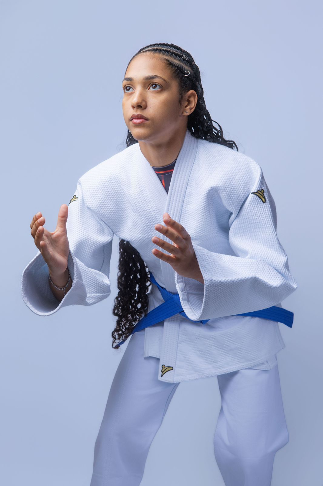 Atleta em posição de luta vestindo Kimono Série Ouro branco para Judô
